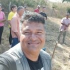 Kevin in a field with farmers