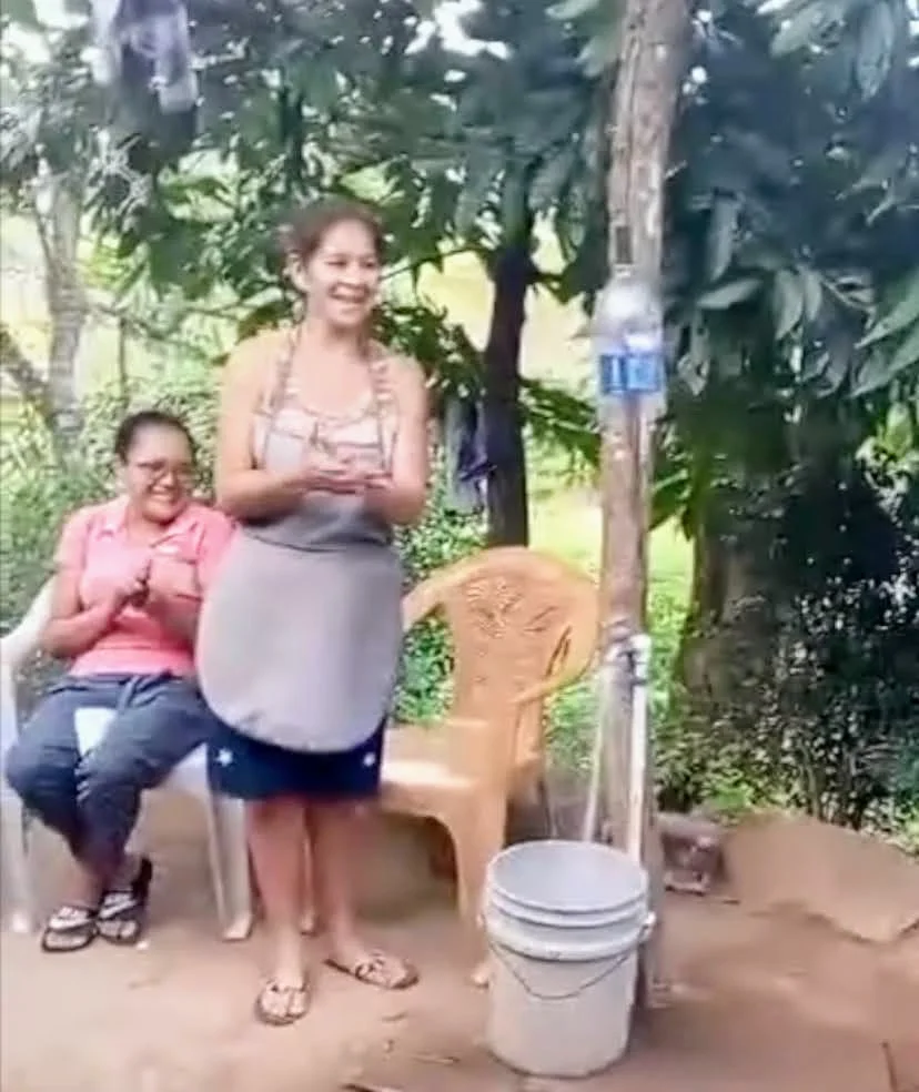 people celebrating turning on water to their house!